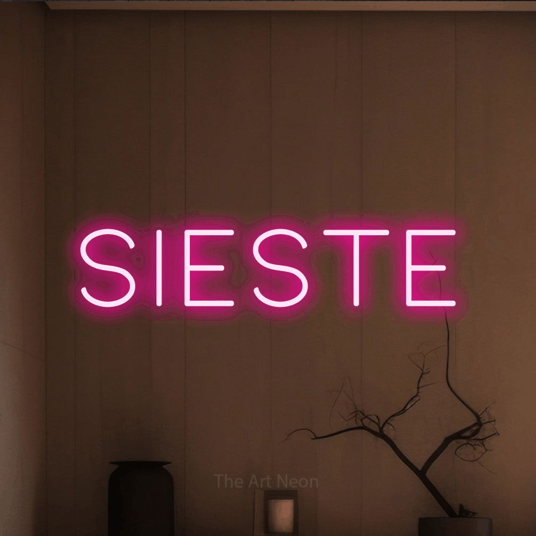“Sieste” LED neon sign in hot pink, with thin, widely spaced lettering, shown against a simple earth-toned interior.