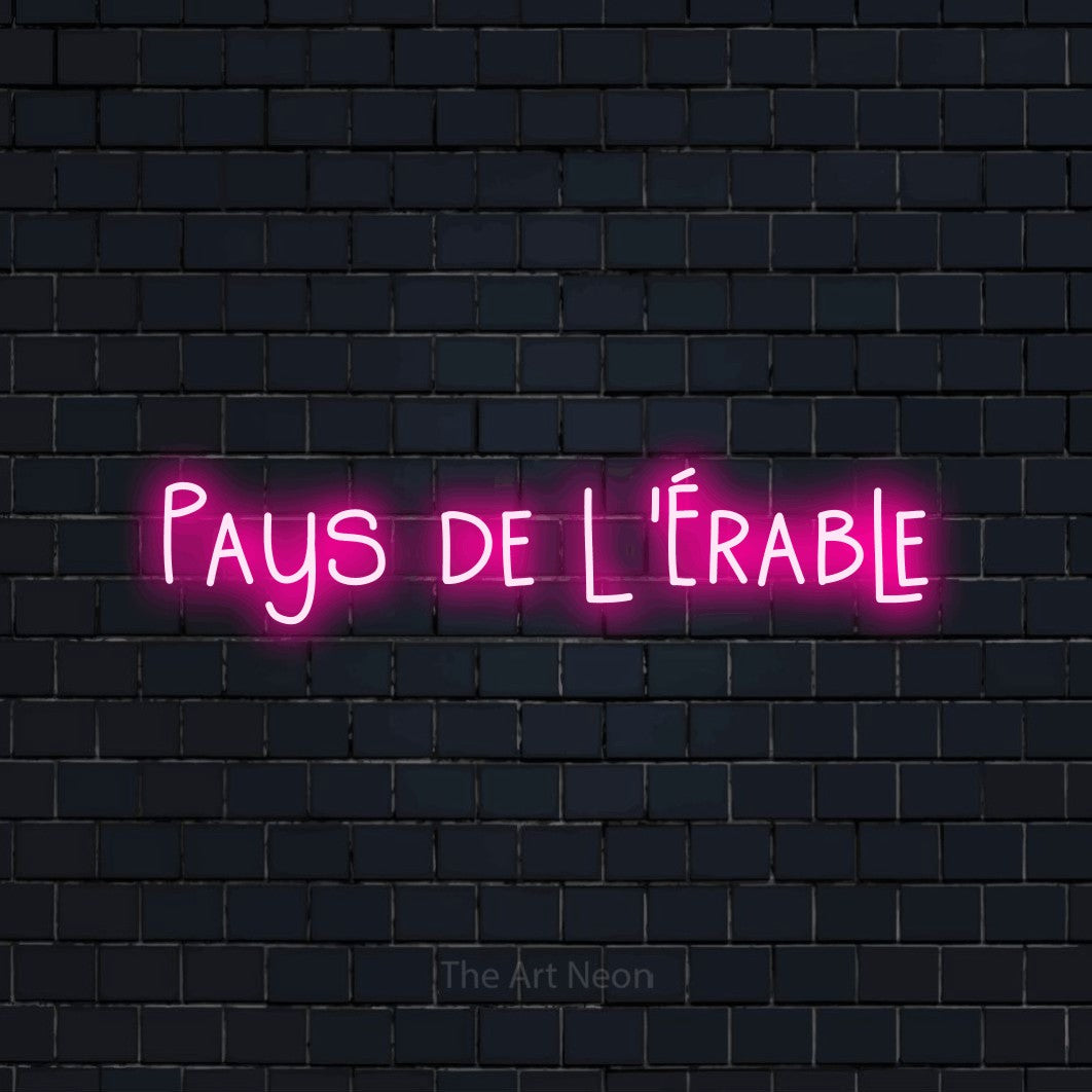 Aperçu d’une enseigne néon LED « Pays de l'érable » en rose vif, en lettres étroites dessinées à la main, photographiée sur un mur de briques bleu marine foncé, pour un décor canadien.