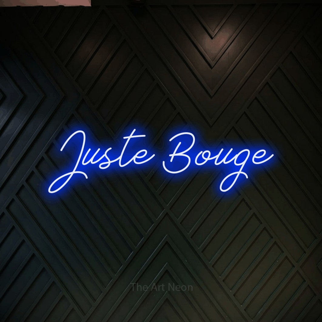 Aperçu d’une enseigne néon LED « Juste bouge » en bleu, en lettrage cursif, photographiée sur un mur en bois noir à motif chevron, pour un espace d’entraînement.