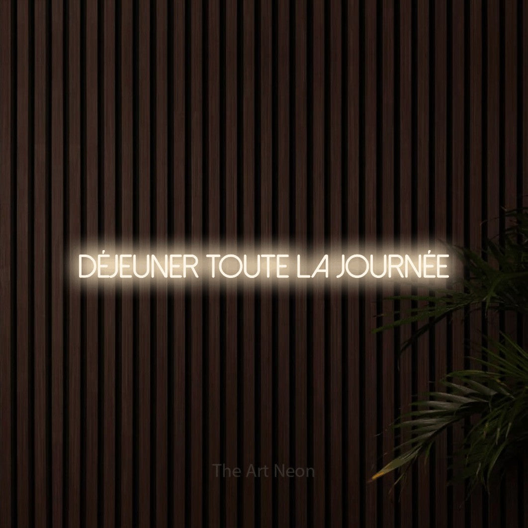 Lettrage en néon LED « Déjeuner toute la journée » en blanc chaud, en lettres fines sans empattement, présenté sur un mur de lattes en bois foncé, pour un restaurant.