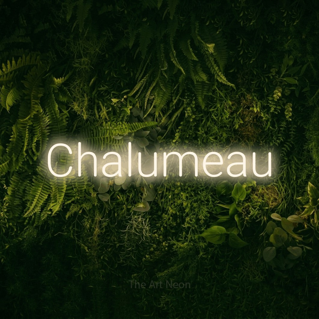 “Chalumeau” LED neon sign in warm white, with rounded sans-serif lettering, shown against a dark moss and forest backdrop.