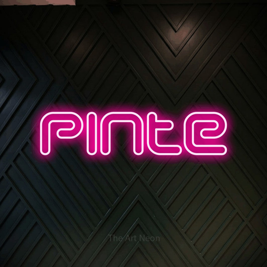 “Pinte” LED neon sign in hot pink, with futuristic double-line lettering, shown against a black chevron-patterned wood wall.