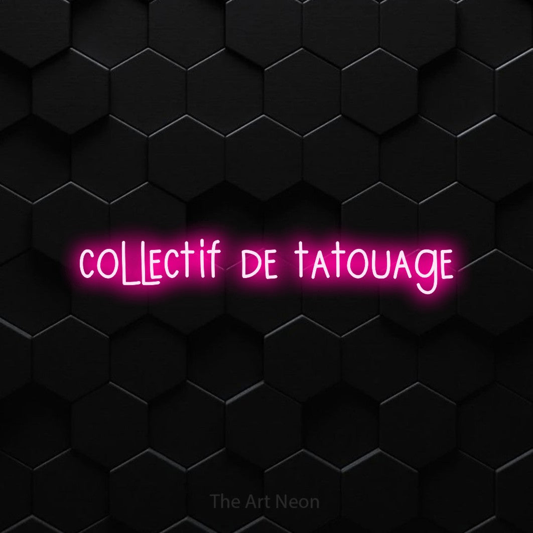 “Collectif de tatouage” LED neon sign in hot pink, with narrow hand-drawn lettering, shown against black hexagonal wall tiles.